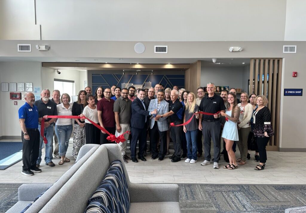 Peotone Chamber members pose with manager Tom Forbes and owner Suhas Patel for the ribbon cutting ceremony at the first anniversary celebration. Photo by Andrea Arens.