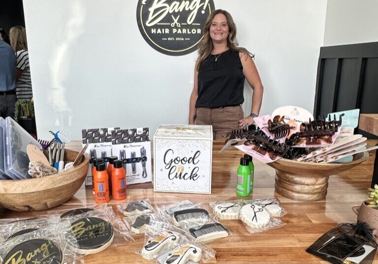 Christina Clark proudly poses at the reception desk of her new salon, Bang Hair Parlor, in downtown Peotone. Photo by Andrea Arens